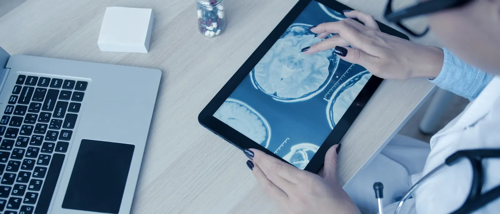 Médica analisando exames de imagem em um tablet